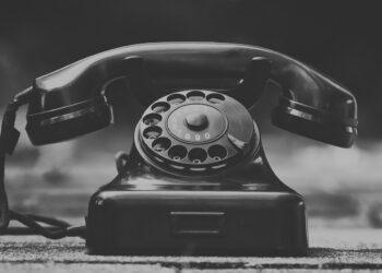 Ferro antigo de telefone fixo em preto e branco, símbolo de comunicação clássica.