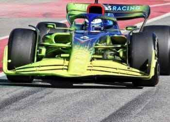 Carro de F1 com tinta verde estranha na pista de corrida.
