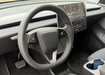 Volante do Tesla Model Y com painel digital e interior moderno.