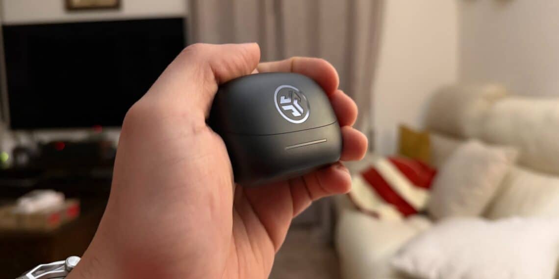 Árvore de tags (ALT): Fone de ouvido JLab JBuds Pods ANC em mão, tecnologia de cancelamento de ruído.