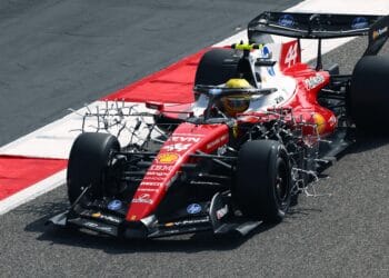 Carro de F1 com tinta verde estranha na pista de corrida.